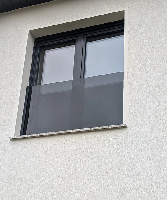 Graue Glassicherung vor einem Fenster von außen fotografiert