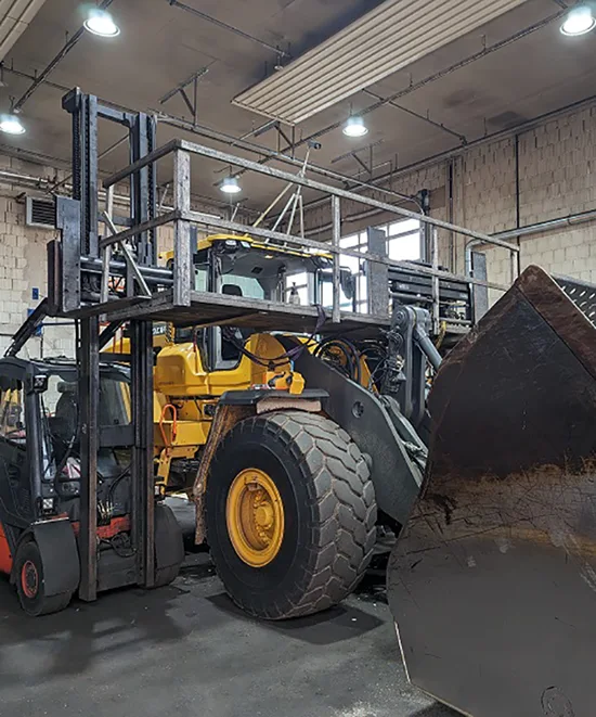 Großer Bagger in einer Halle der neu verglast wird