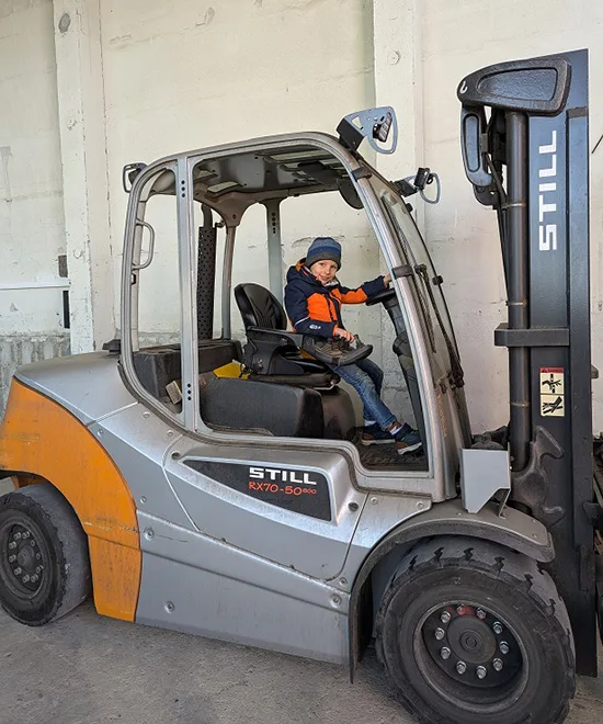 Kind sitzt in einem Gabelstabler